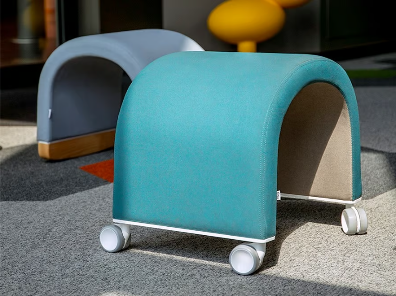 NOMAD - Upholstered low fabric stool with castors by Askia
